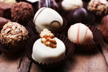 Many chocolates on wooden textured background