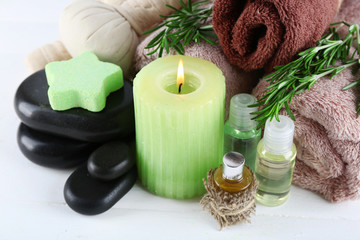 Fototapeta na wymiar Branches of rosemary and sea salt, towels, candle and bottle