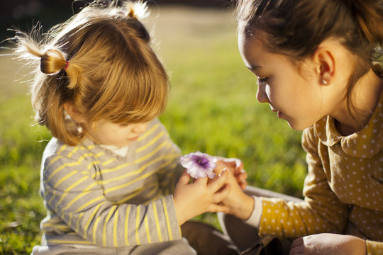 Ni&ntilde;a dando flor a ni&ntilde;a peque&ntilde;a