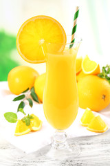 Glass of orange juice with straw and slices