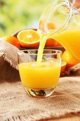 Pouring orange juice from glass carafe,