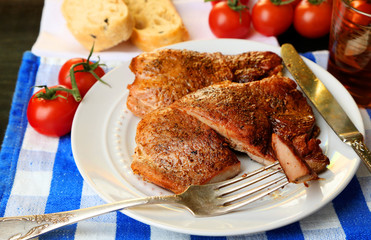Roasted meat and vegetables on plate, on wooden table