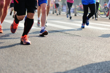	marathon athletes legs running on city road