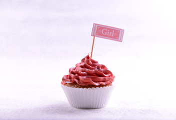 Delicious cupcake with inscription on table on beige background