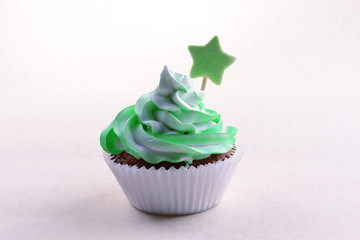 Delicious cupcake with inscription on table on beige background