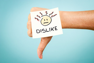 Dislike concept with hand on blue background