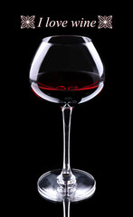 Wineglass with red wine and I love wine text, isolated on black