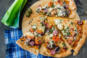 chopped pieces of pizza with mushrooms, olives and salami