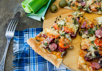chopped pieces of pizza with mushrooms, olives and salami
