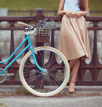Young beautiful, elegantly dressed woman with bicycle