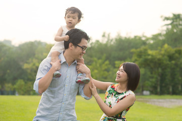 Fototapeta premium Happy Asian Family enjoying family time together in the park