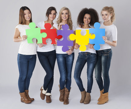 Multi ethnic girls with colored jigsaw puzzle