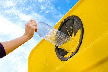 Throwing a bottle into the recycling container