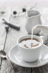pouring milk from jug cup black coffee