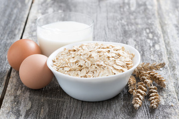 oatmeal, eggs and milk on wooden background