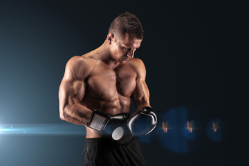 Muscular man in studio on dark background