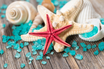 Close-up of red starfish seashell on old wooden board.