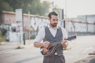 Fototapeta na wymiar handsome big moustache hipster man playing mandolin