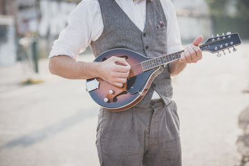 Fototapeta na wymiar handsome big moustache hipster man playing mandolin