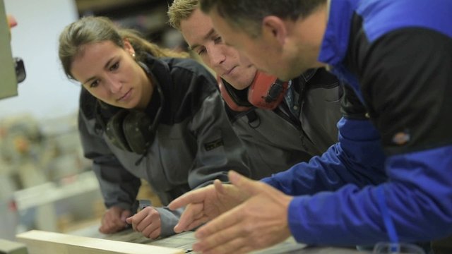 Carpenter instructor with students in workshop