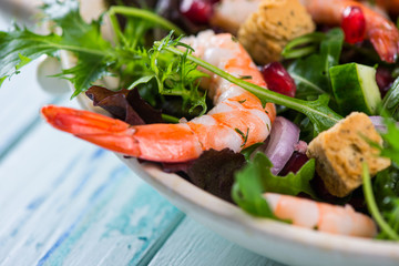 Fresh organic salad with prawns from above on table