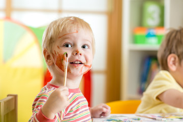 smiling kid painting at home