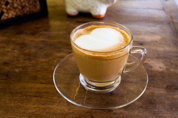 Cup of hot espresso coffee on wooden table.