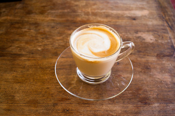 Cup of hot espresso coffee on wooden table.