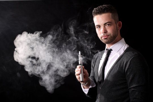 Homme &eacute;l&eacute;gant avec une e-cigarette