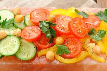 Vegetable salad on pink salt block