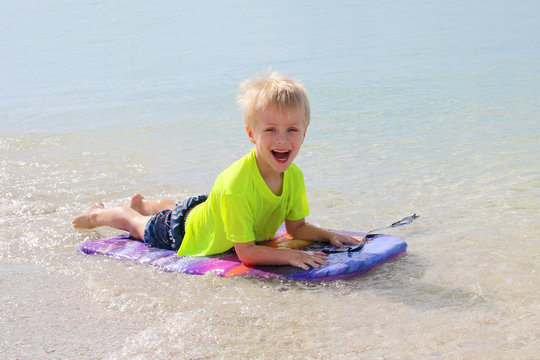 Young Child Riding on Boogie Board in Ocean