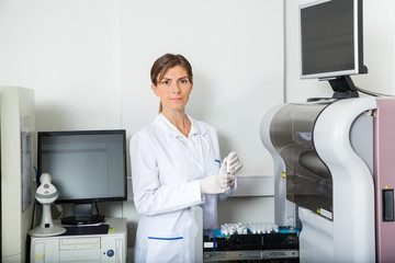 Scientist Loading Coagulation Analyzer With Samples
