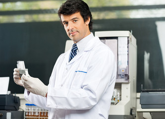 Confident Scientist Analyzing Urine Samples In Lab