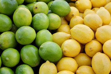Pile of Fresh Yellow Lemons and Green Limes at Farmer's Market