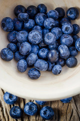 Blueberries in a bowl on a wooden table.