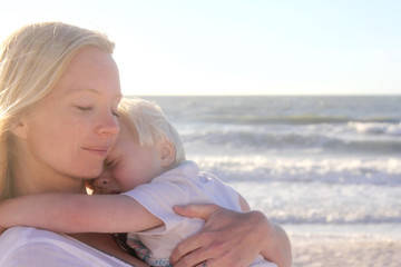 Young Child Protect Safely in Mother's Loving Embrace on Beach