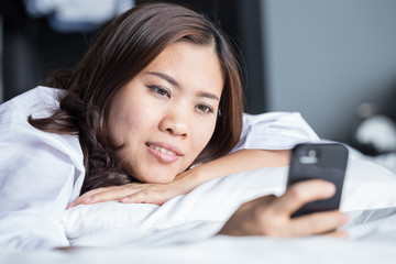 Young happy asian woman using smartphone