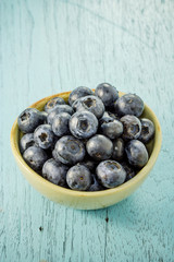 Blueberries in a bowl on a wooden table.