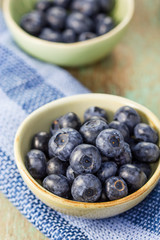 Blueberries in a bowl on a wooden table.