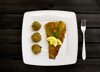 Fried fillet with cabbage and mushrooms on white plate