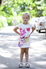 Portrait in full growth of a little girl in a summer dress