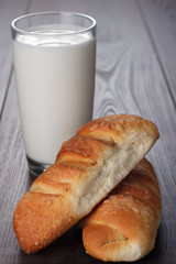 glass of milk and fresh buns on the table