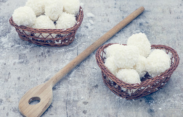 Arrangement of coconut cookies on brown baskets and wooden spoon