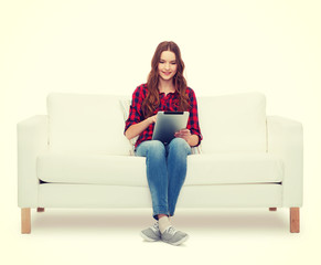 teenage girl sitting on sofa with tablet pc