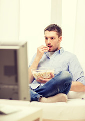 smiling man watching sports at home