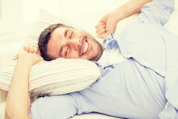 smiling young man lying on sofa at home