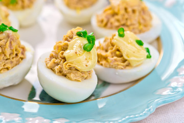 delicious stuffed eggs on blue plate.