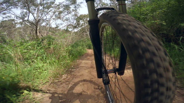 Mountain biking on a dirt road, front suspension fork view