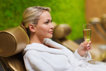 beautiful young woman drinking champagne at spa