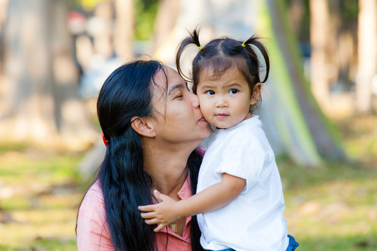 Mother and daughter are hug and kiss. Family is Thailand.